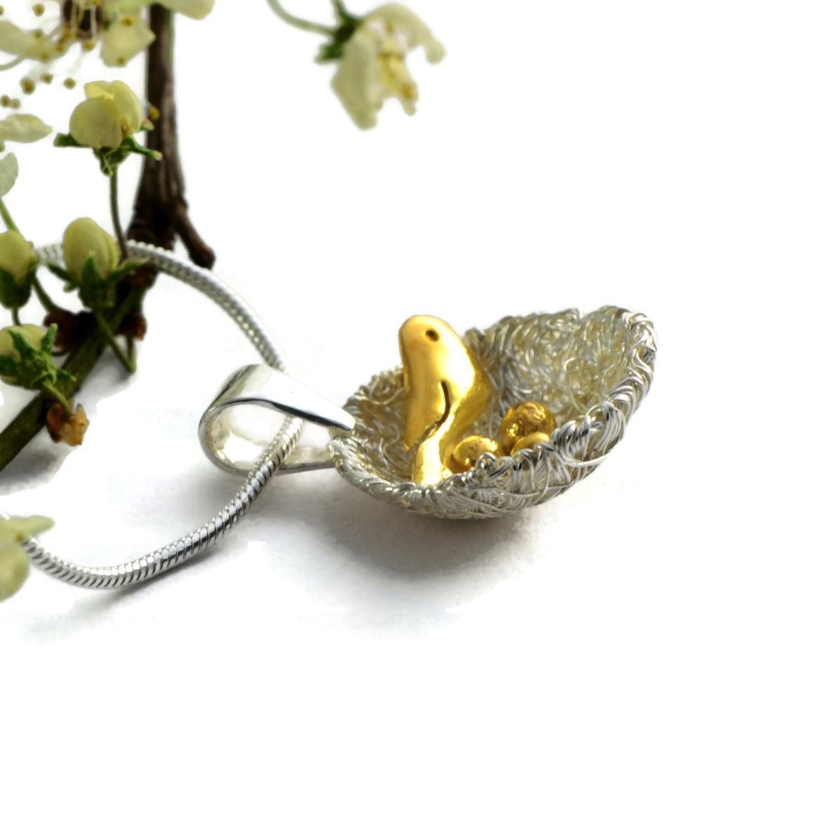 Bird's nest pendant with golden bird and eggs
