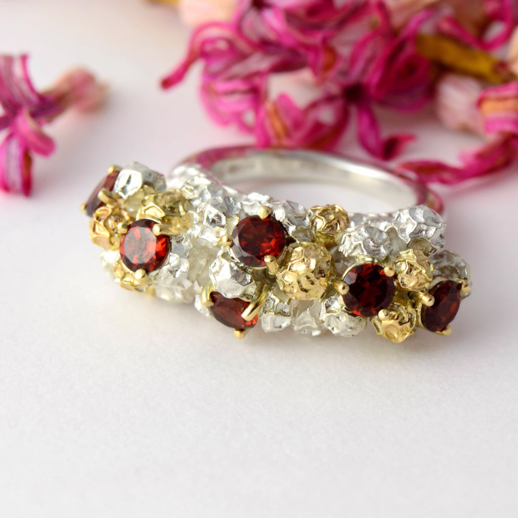 large modern dress ring made in gold, silver and garnets 