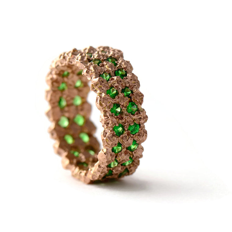 wide etternity ring made in rose gold and green garnets