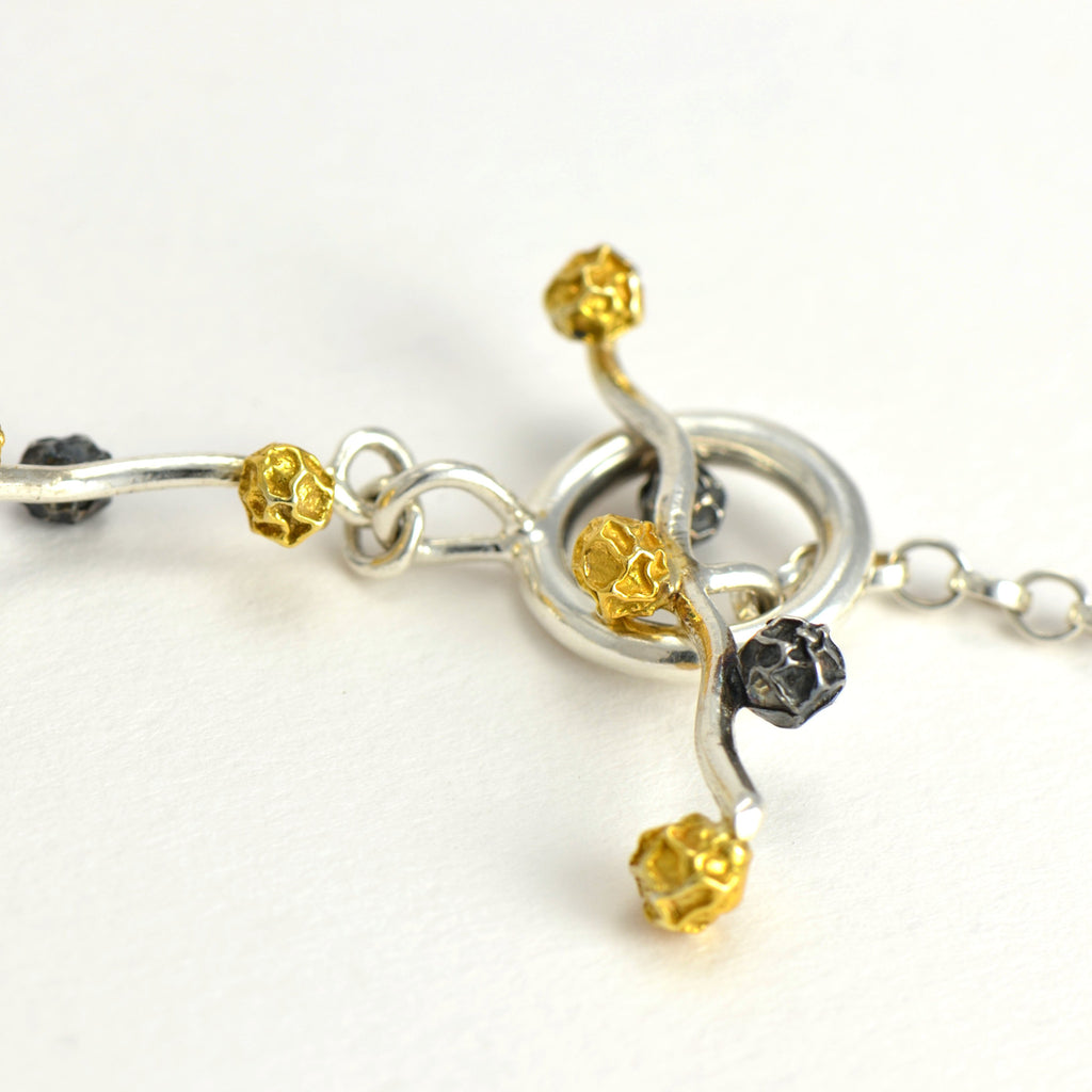 A Floral and fruit bracelet design in sterling silver grains of peppercorn with three colours